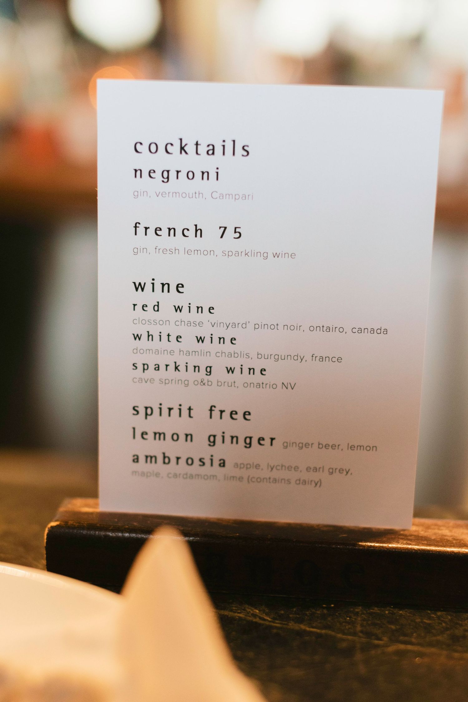 A wedding drink menu displaying cocktail options including French 75 and wine selections.