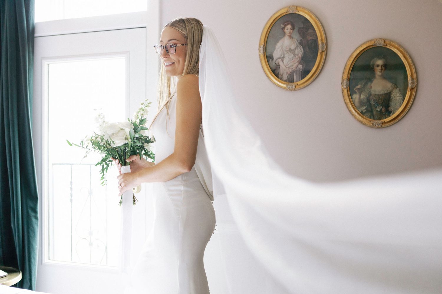 Elegant wedding venue interior with framed artwork and green drapes against cream walls.