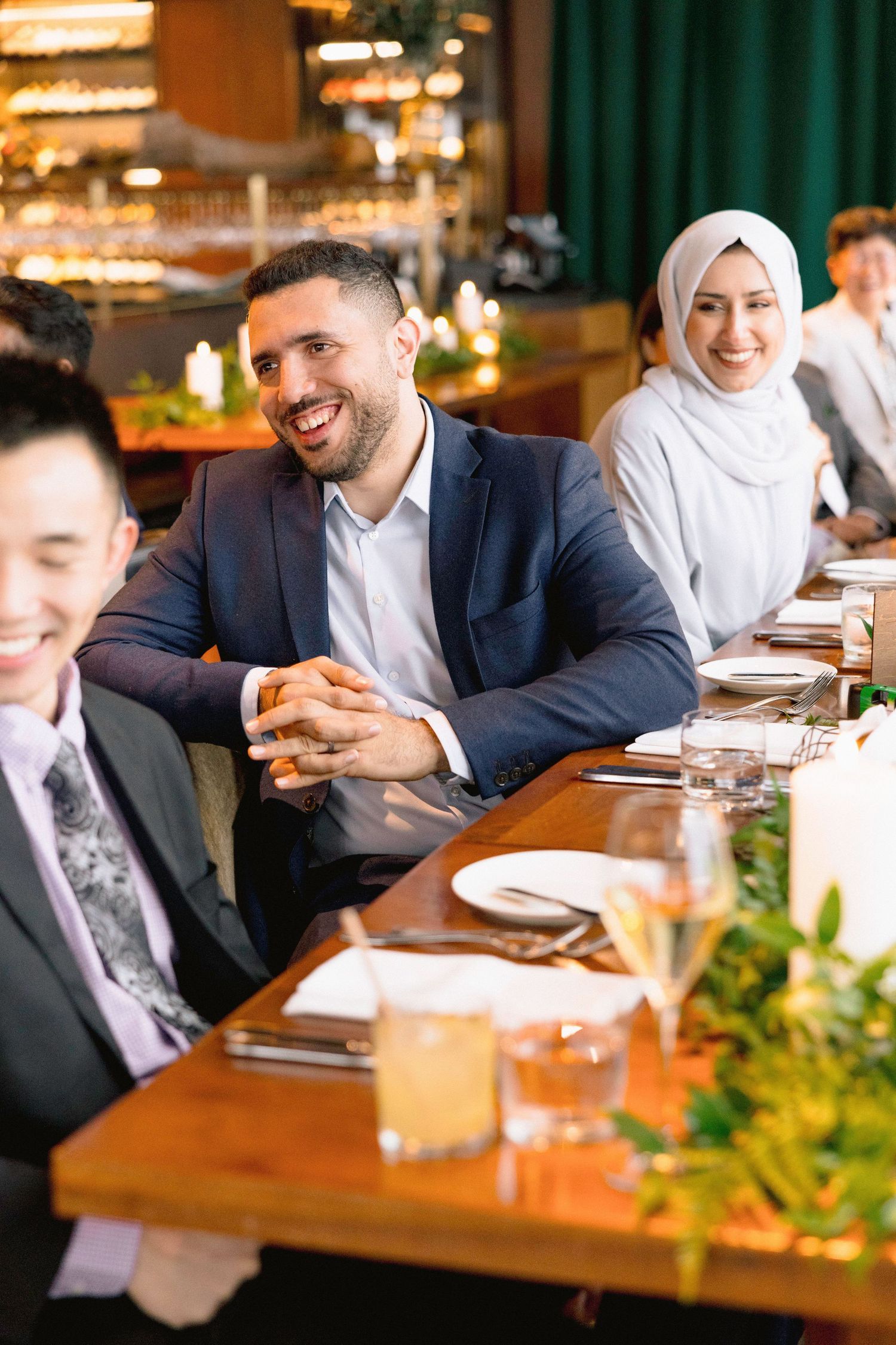 Business professionals gathered around a dining table for a formal meal in a restaurant setting.