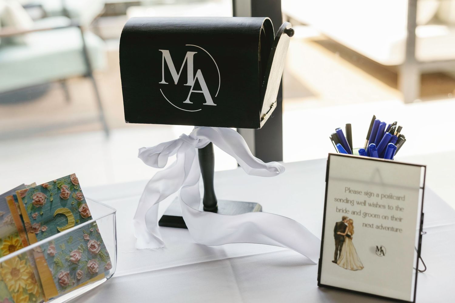 Wedding reception detail featuring a black mailbox with monogram and decorative cards.