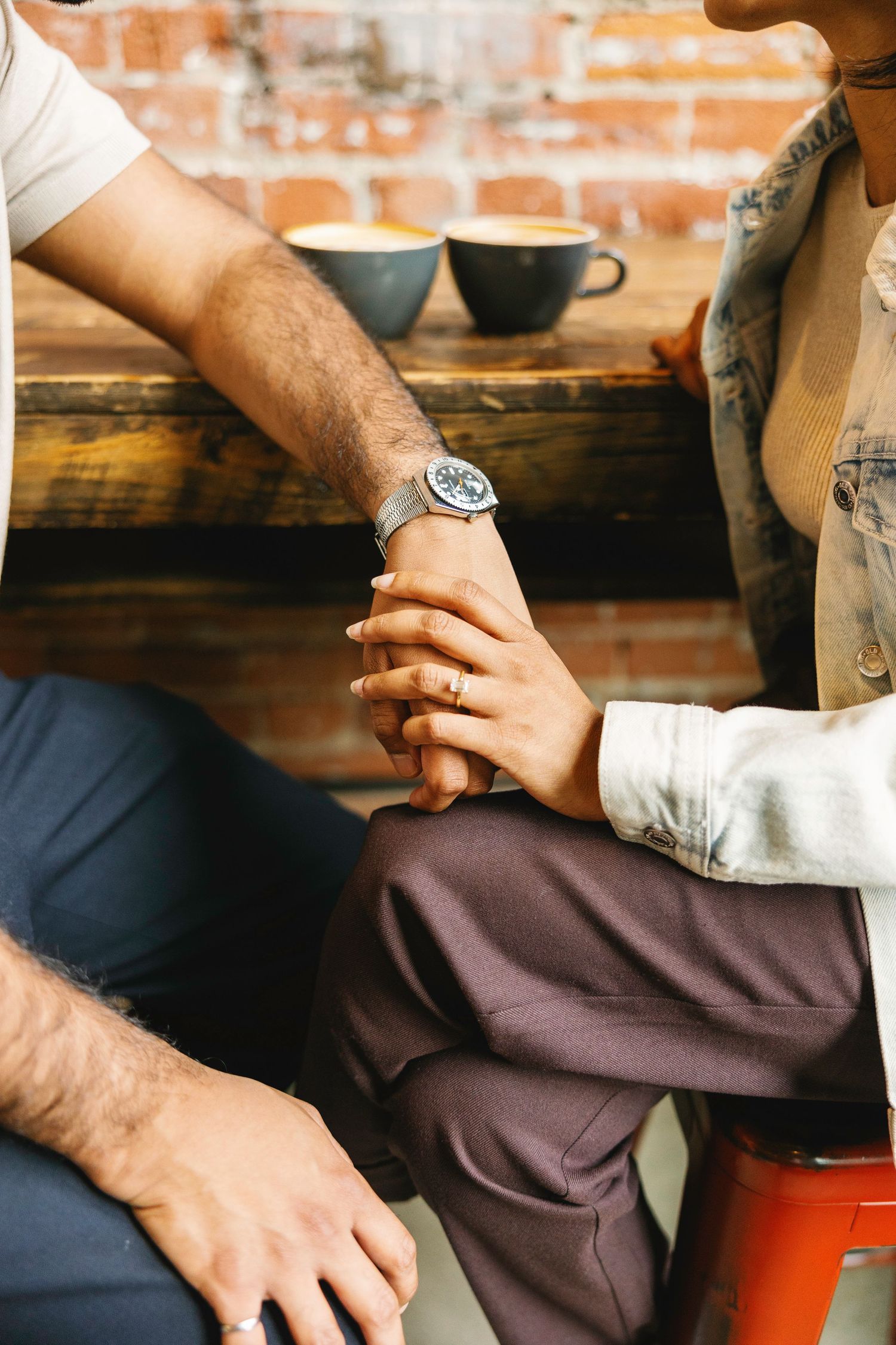 Close-up detail shots of hands and rings in casual intimate setting.