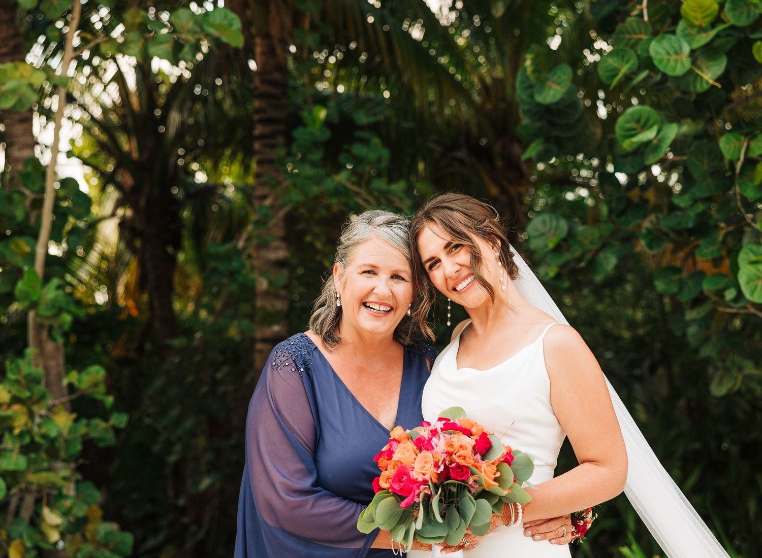 Wedding party members gather outdoors for group photos surrounded by lush greenery.