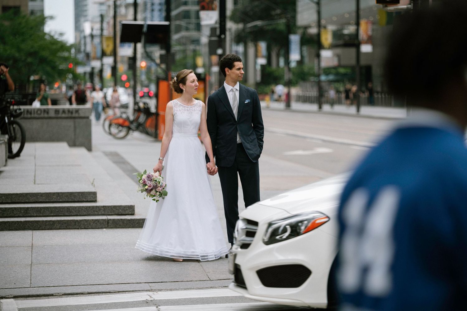 Urban wedding photography with city streets and modern buildings in background.