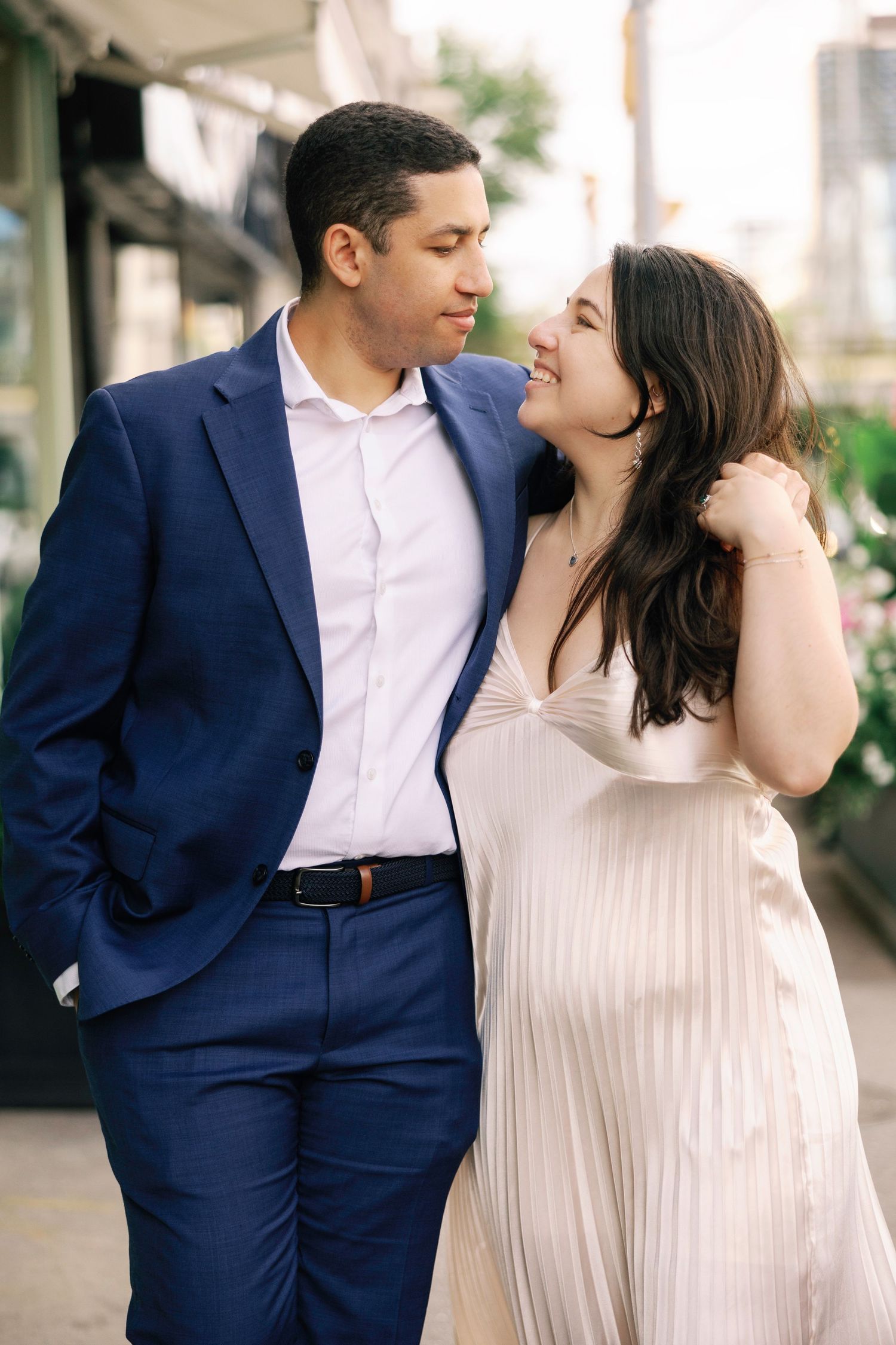 Engagement photos of couple in formal attire sharing intimate moments outdoors.