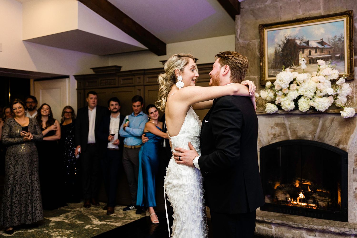Wedding reception dance floor filled with guests celebrating under ambient lighting.