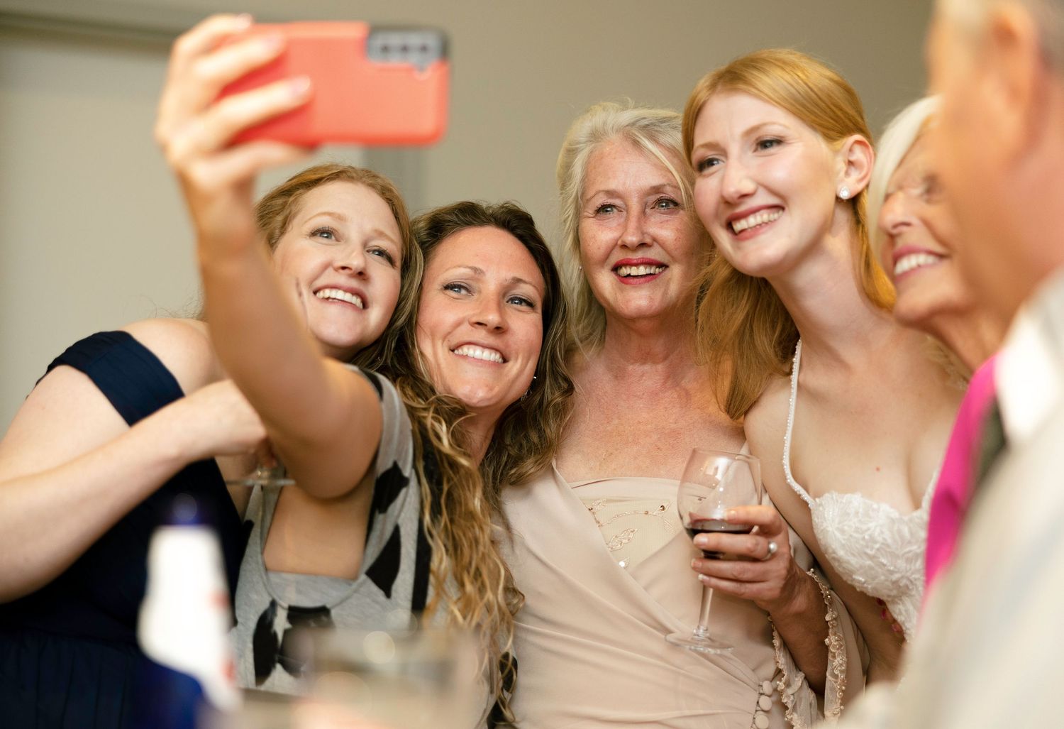 A group of people taking selfies and celebrating together at a festive social gathering.
