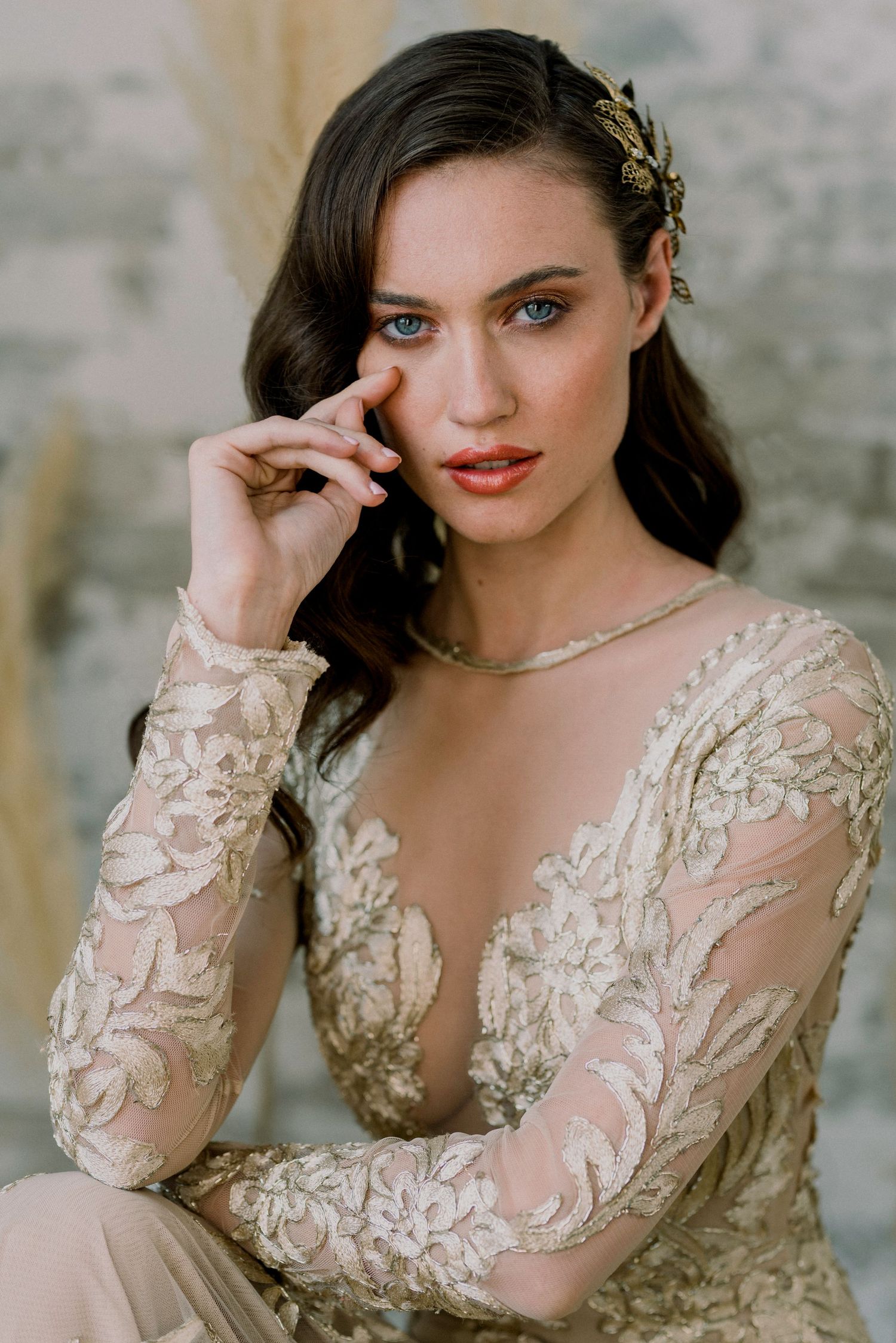 Fashion portrait featuring delicate embroidered dress with floral details in soft natural lighting.