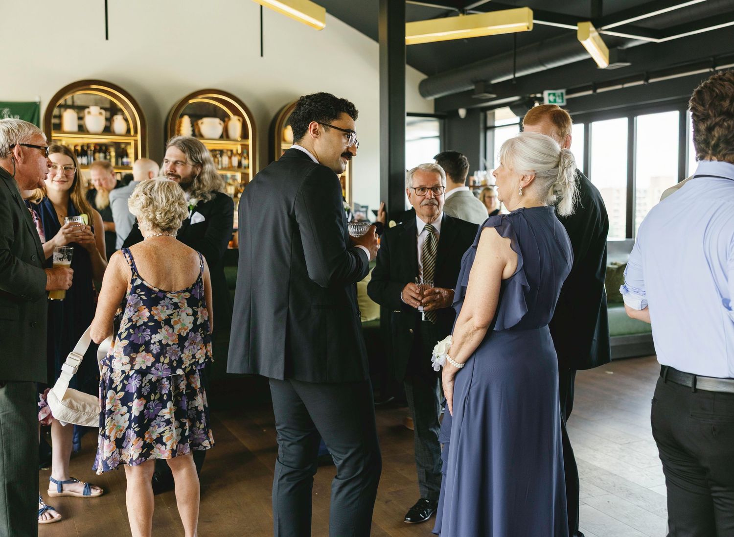 Wedding guests mingling during cocktail hour in an elegant modern venue.