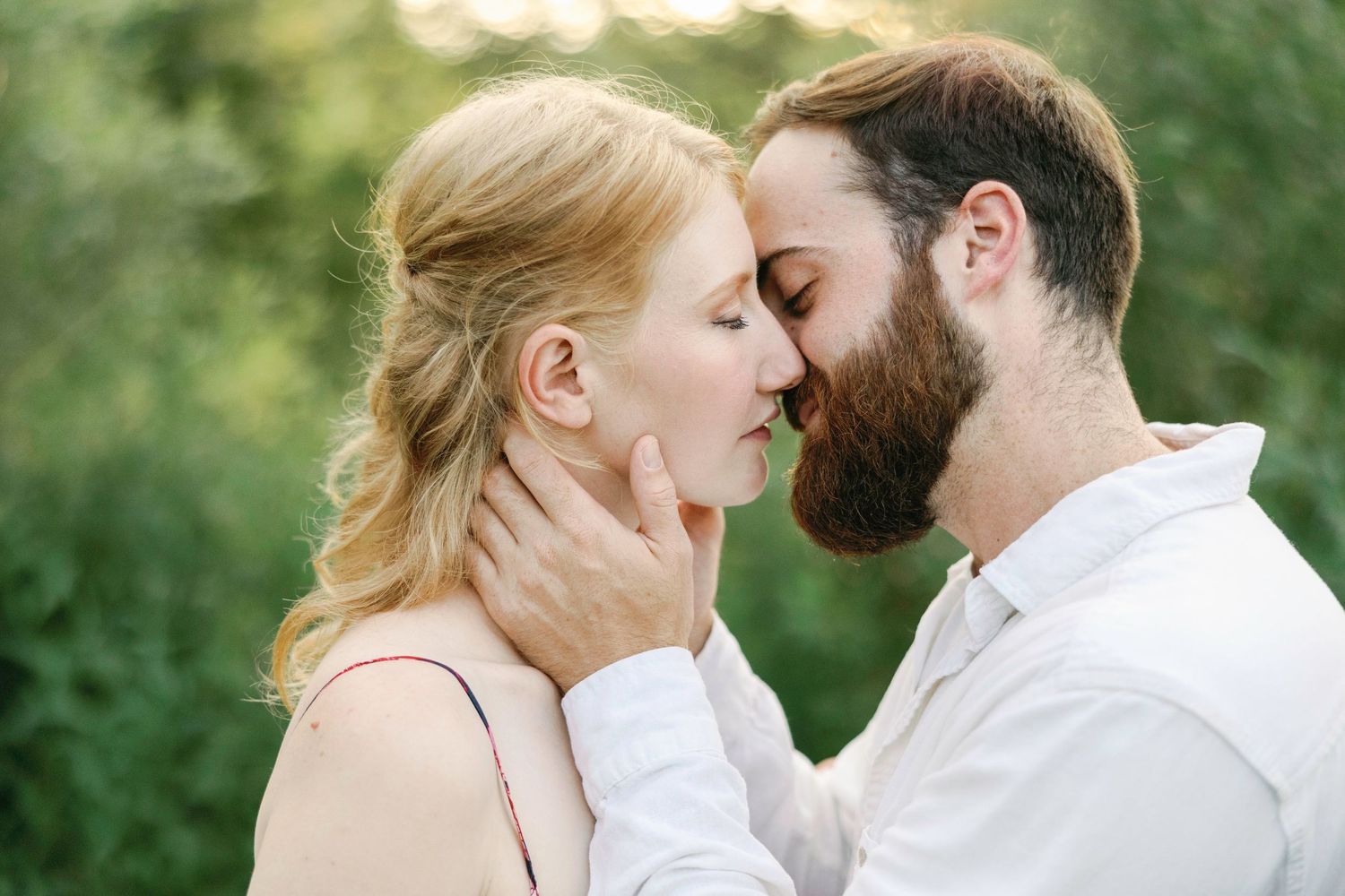 Intimate moment between couple in natural outdoor setting.