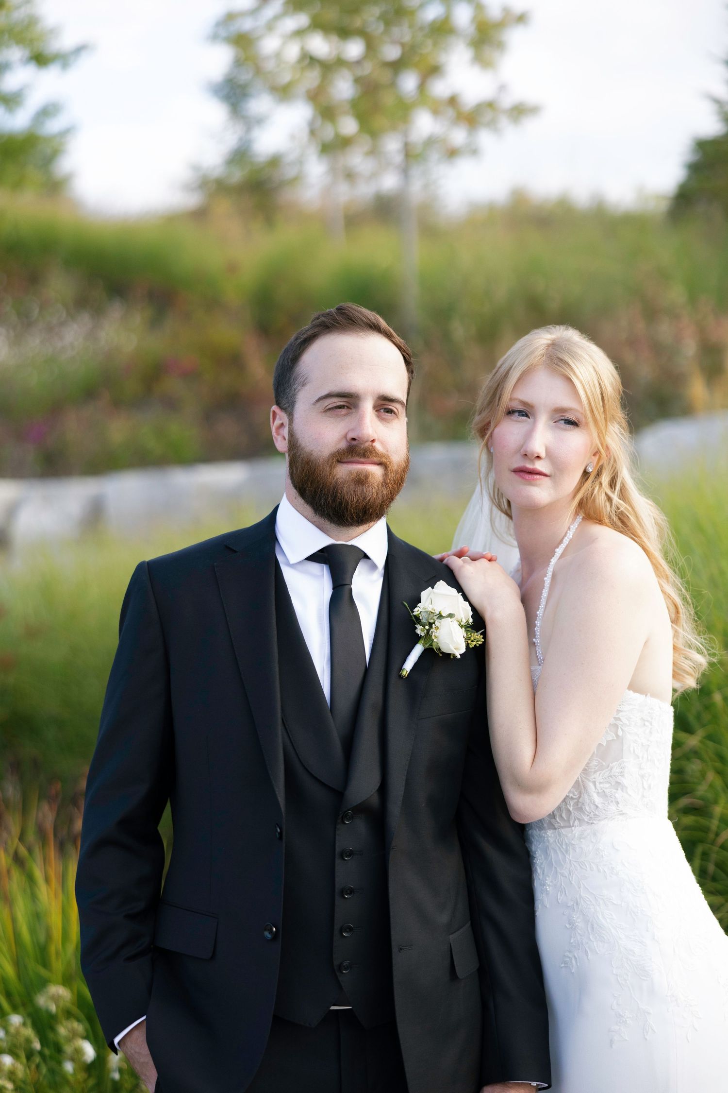 A romantic wedding portrait series showing a couple in formal attire posing together in an outdoor garden setting.