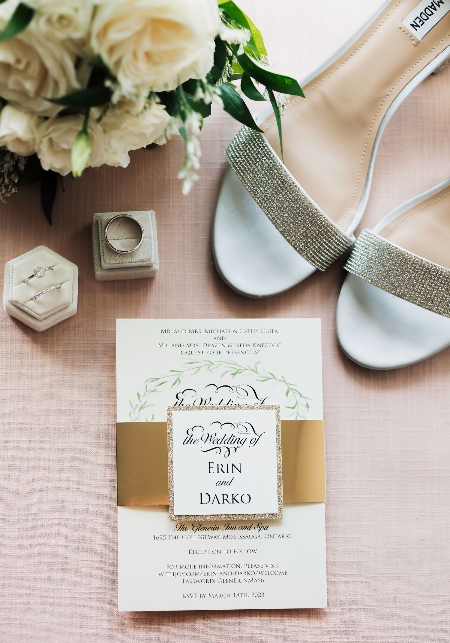 Wedding stationery and bridal accessories flat lay with white roses and silver shoes.