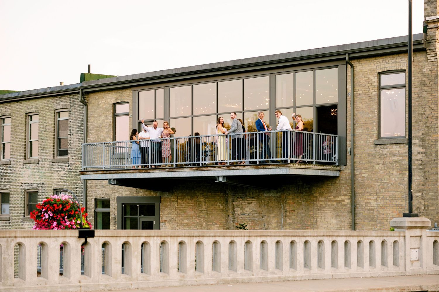 Spectators gather on balconies to watch an event at a historic brick building complex.