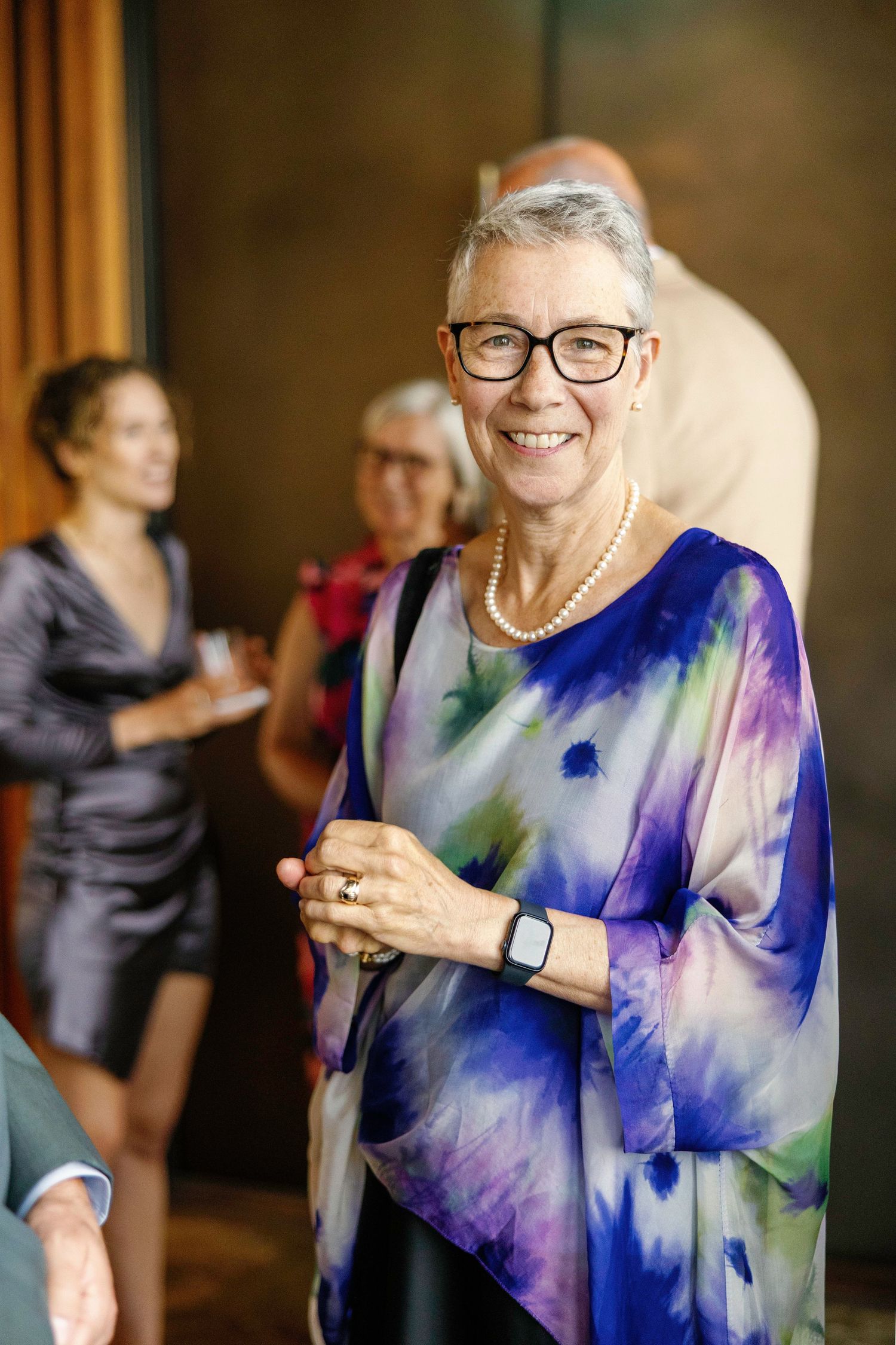 Person wearing a vibrant blue and purple watercolor-style dress at a formal event.