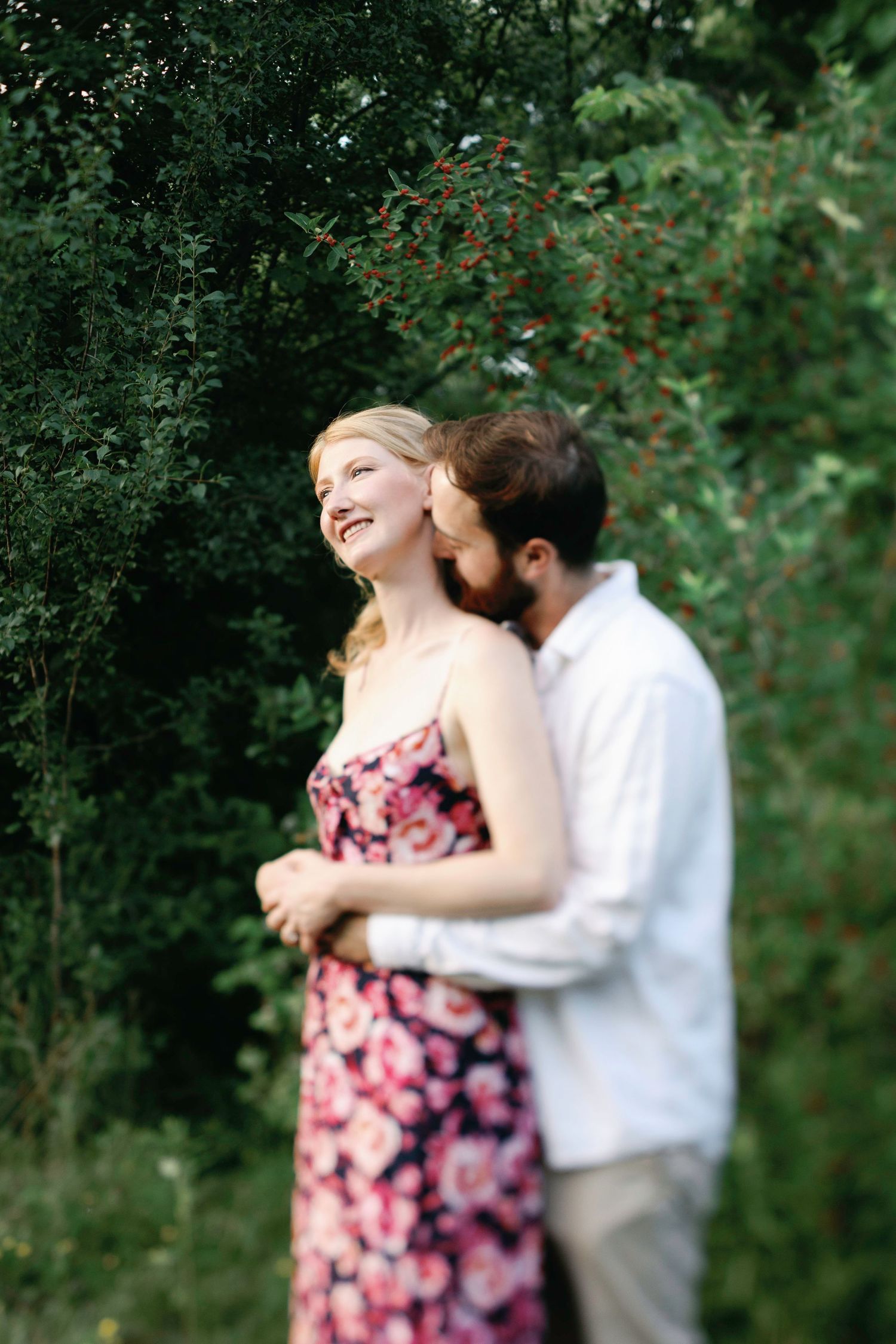 Romantic outdoor photoshoot in a lush garden setting with pink floral dress.