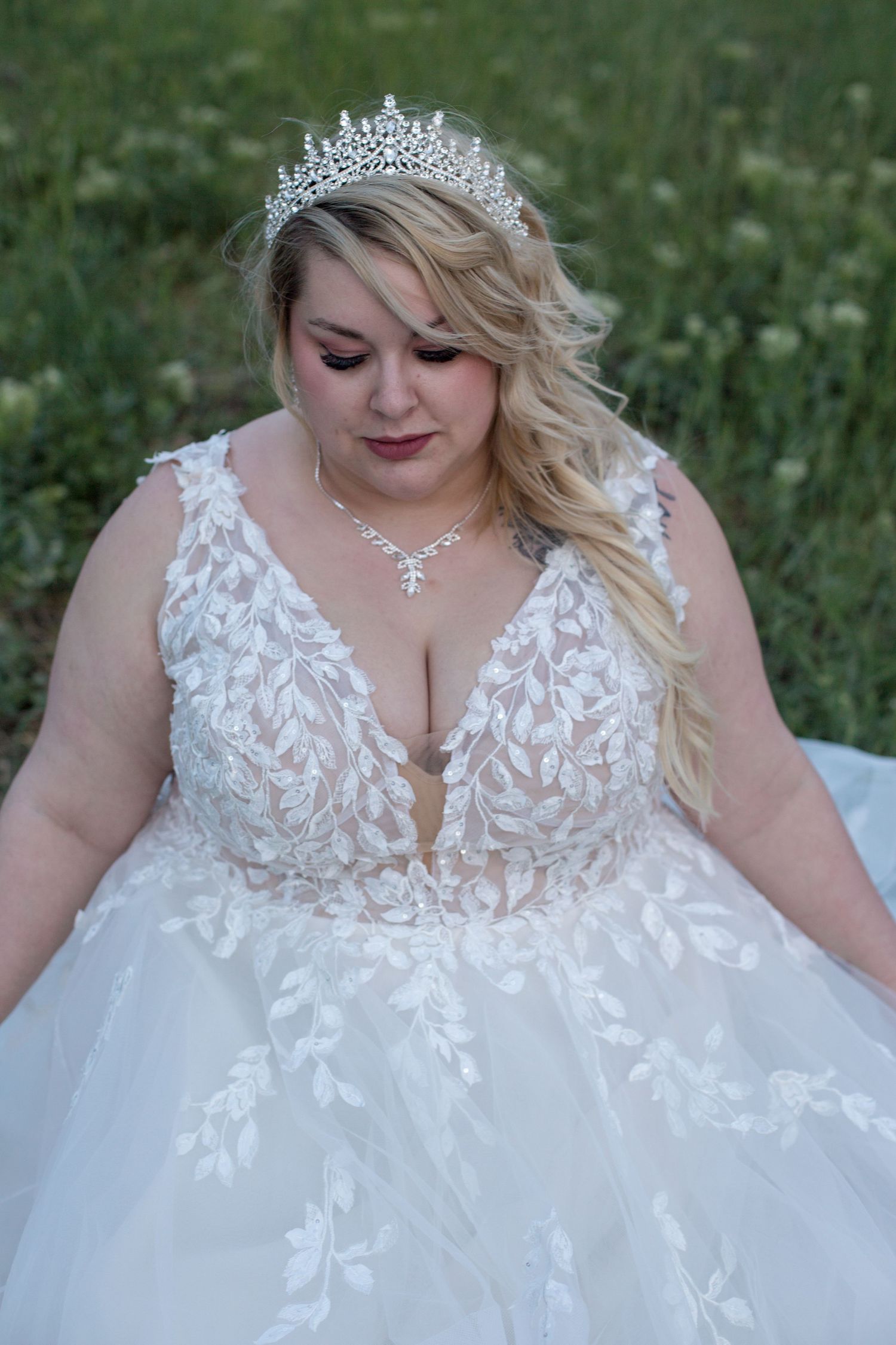 A detailed view of an ornate lace wedding dress bodice adorned with a crystal tiara.