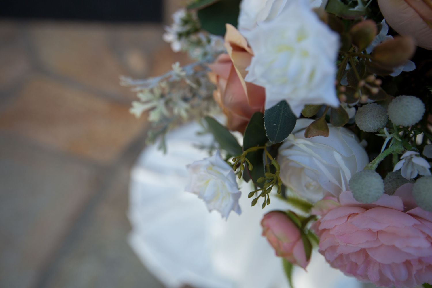 Delicate pink and white floral bouquet with roses and mixed greenery.
