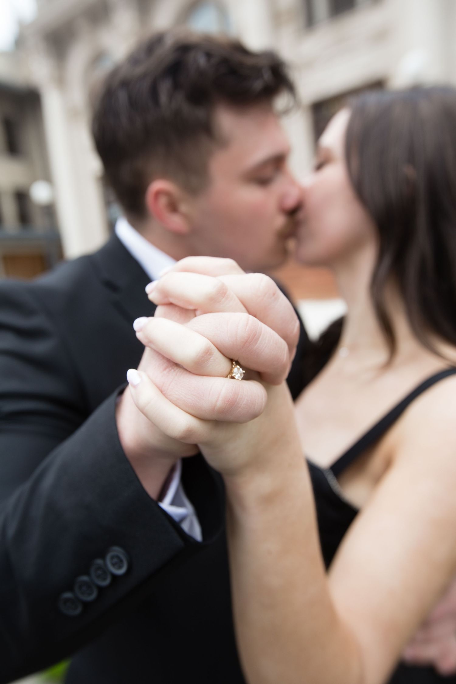 Close-up of clasped hands during romantic moment.