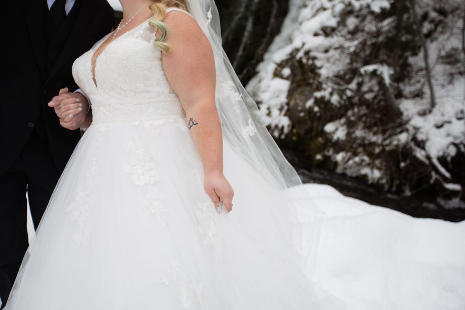 Close-up wedding photography details in snowy outdoor setting.