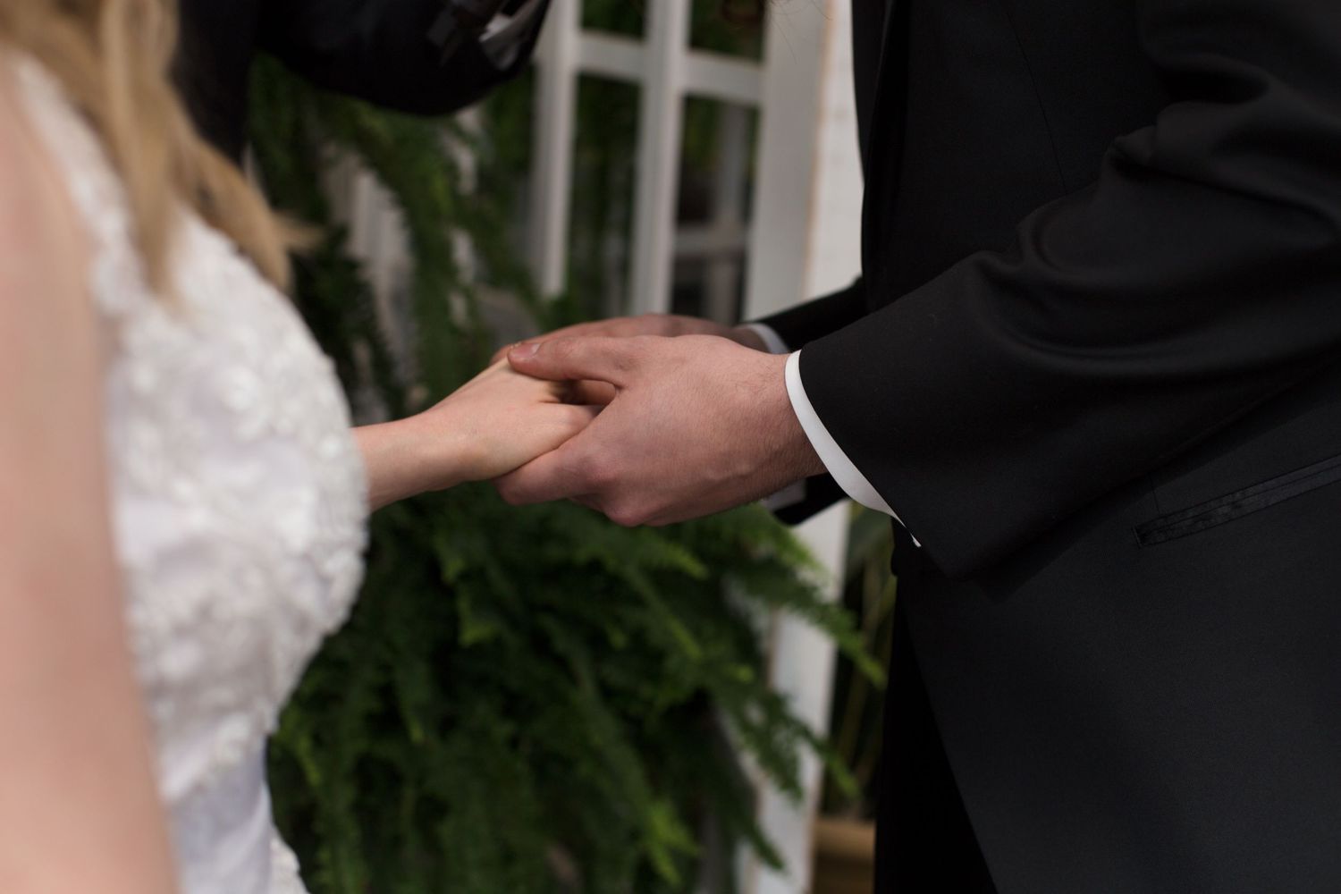 Close-up of hands exchanging rings during wedding ceremony.