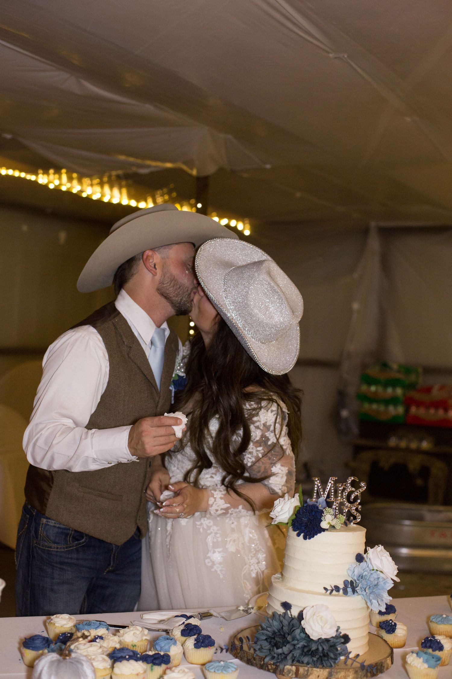 A wedding cake cutting moment captured with western-style decor and blue accents.