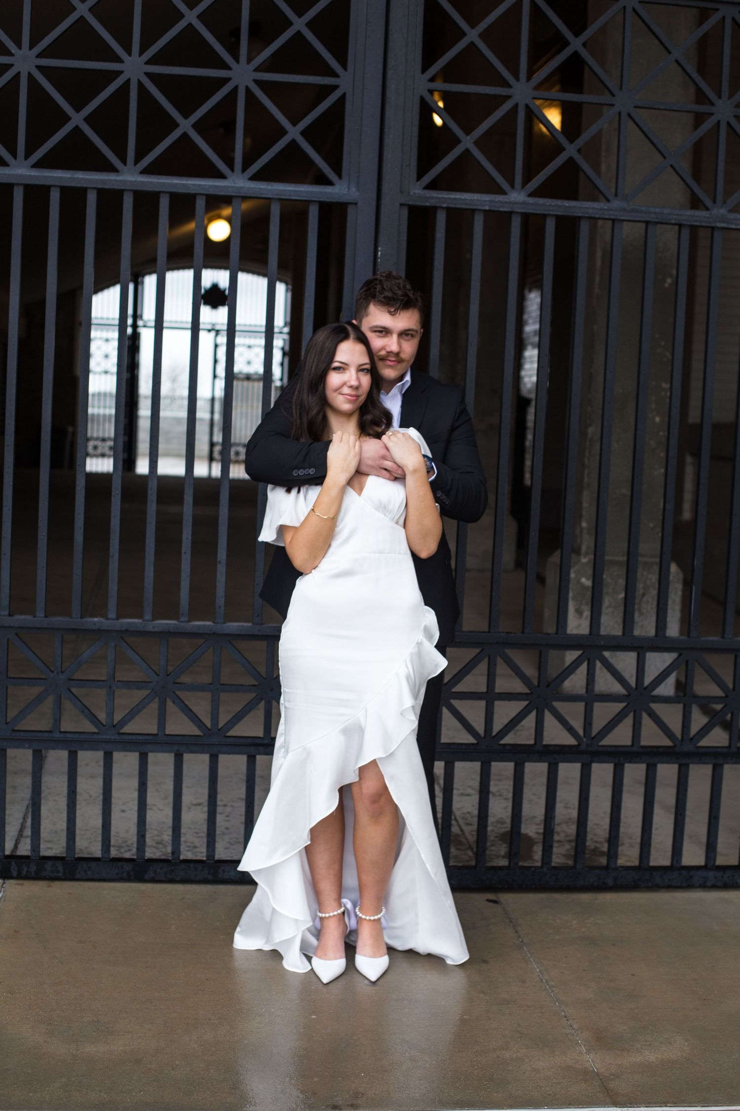 Playful wedding photos showing creative poses against a modern architectural background.