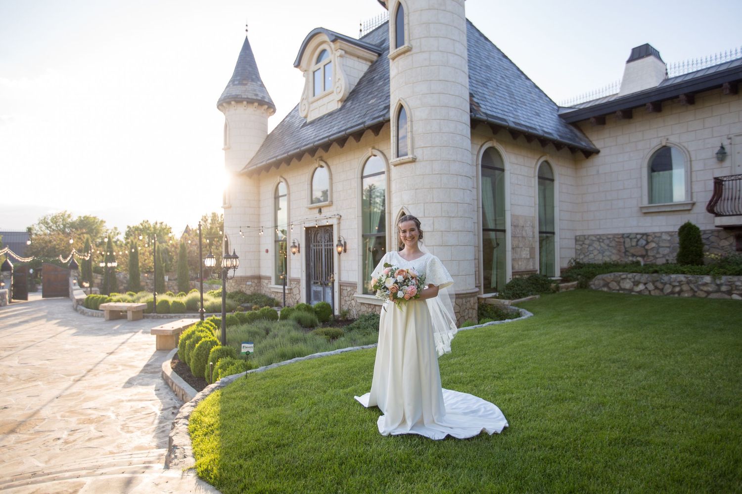 Sunset wedding photography at castle-like chapel with manicured grounds and stone pathways.
