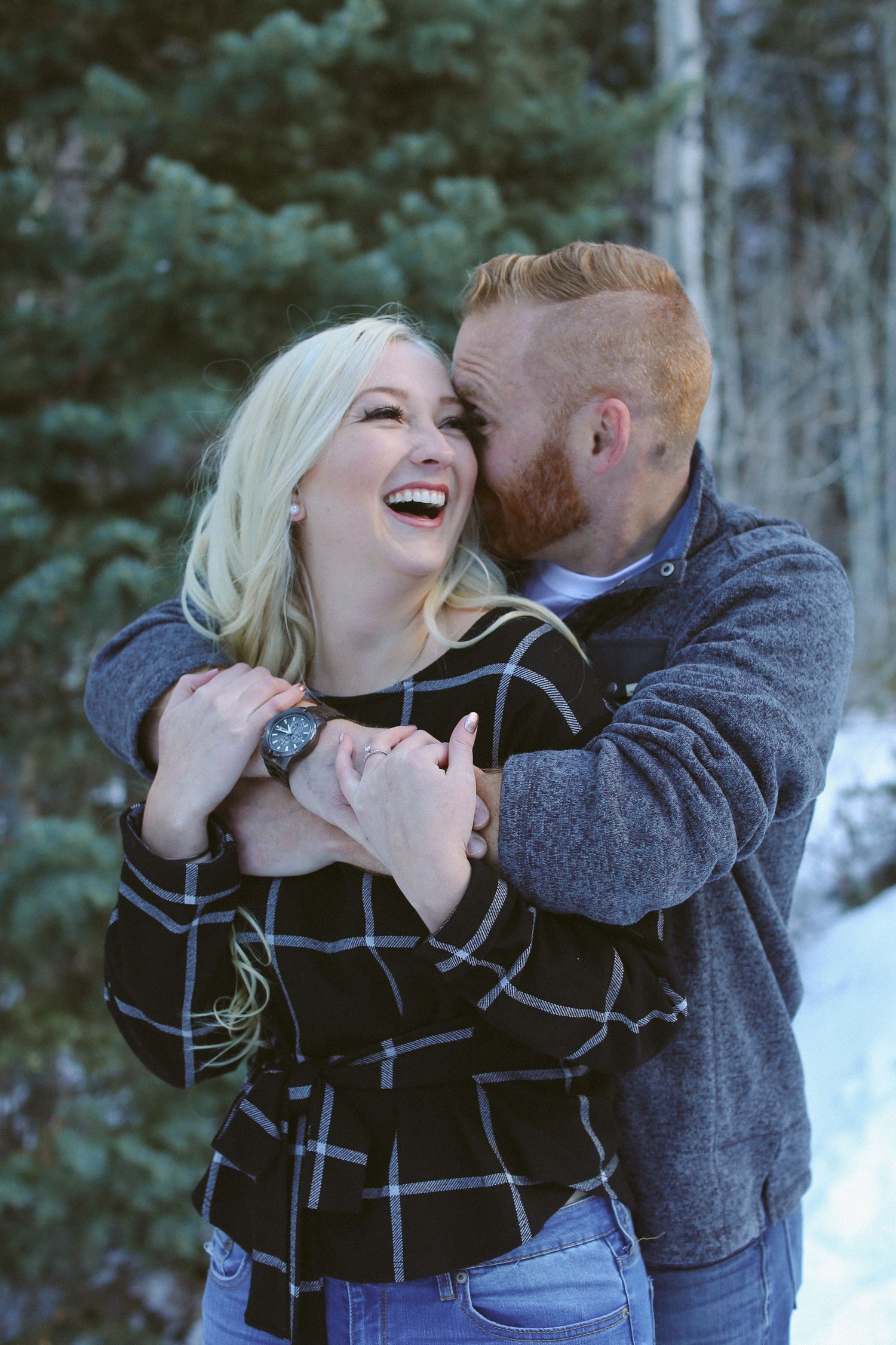 A romantic winter photoshoot shows a couple sharing joyful moments in the snow.