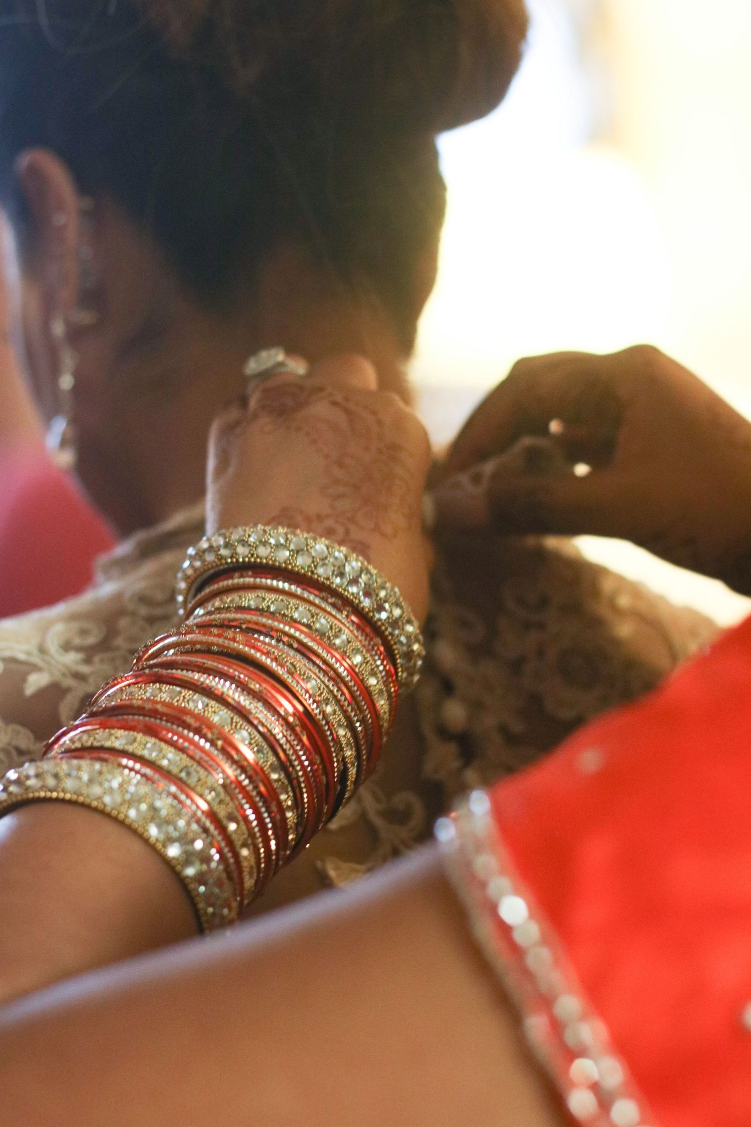 Close-up shot of sparkling bangles and jewelry on wrists.