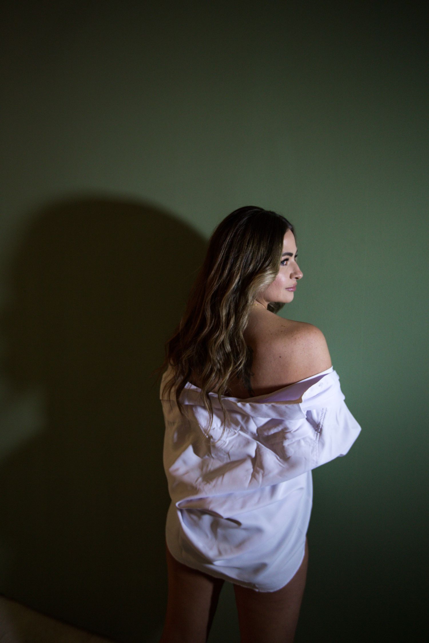 Moody portrait sequence showing artistic poses in white shirt against dark background.