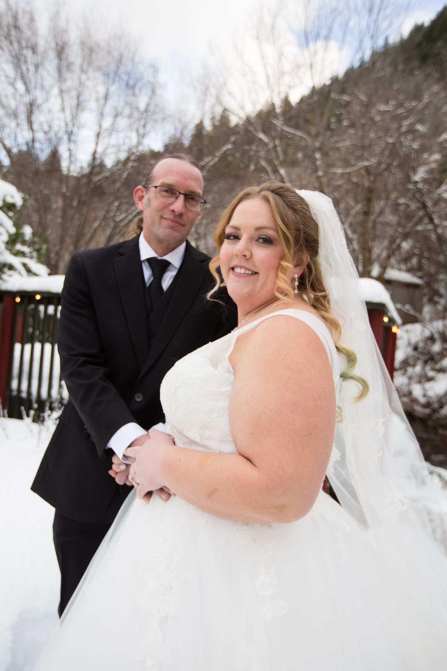 Winter wedding portraits with snow-covered trees and natural lighting.