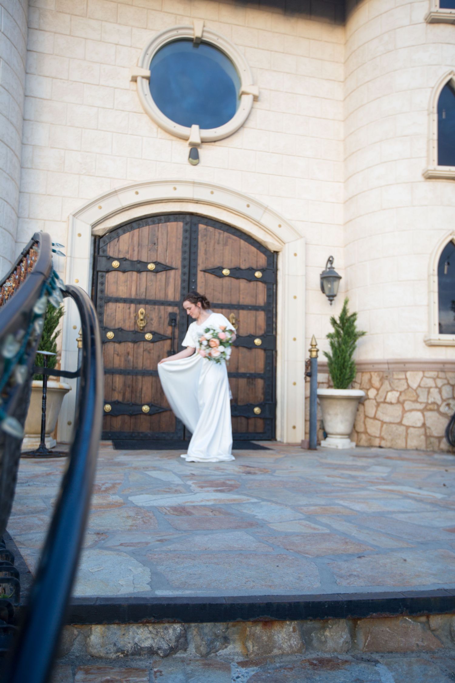 Elegant stone building entrance with large wooden doors and arched architectural details.