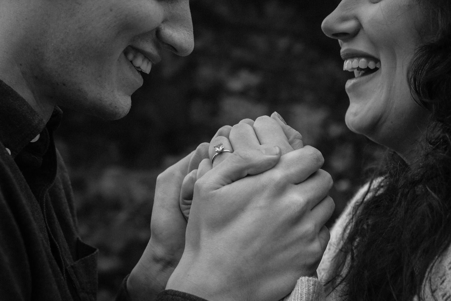 Black and white candid photo capturing a tender romantic moment between a couple.