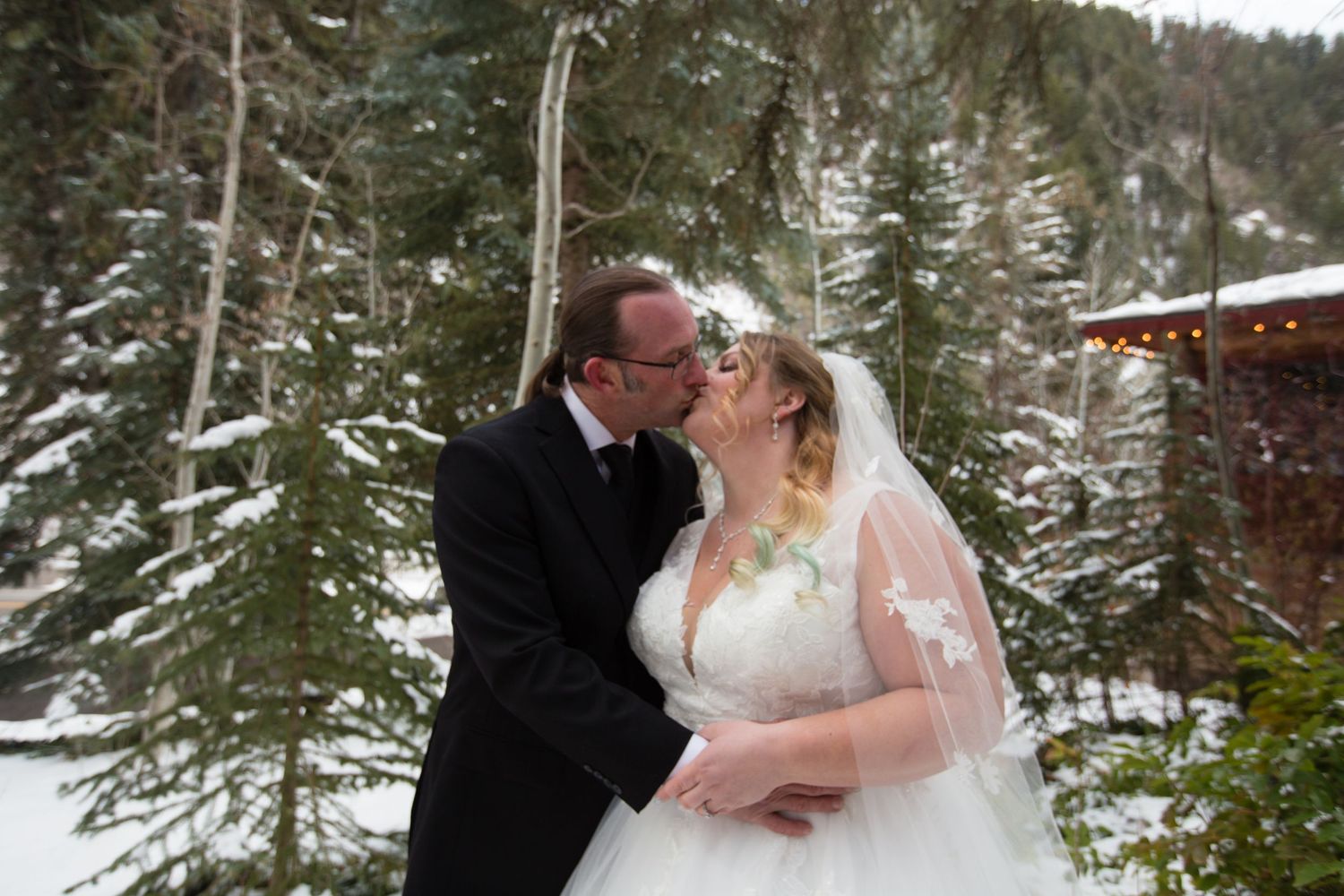 A beautiful winter wedding moment captured in a snowy mountain landscape.