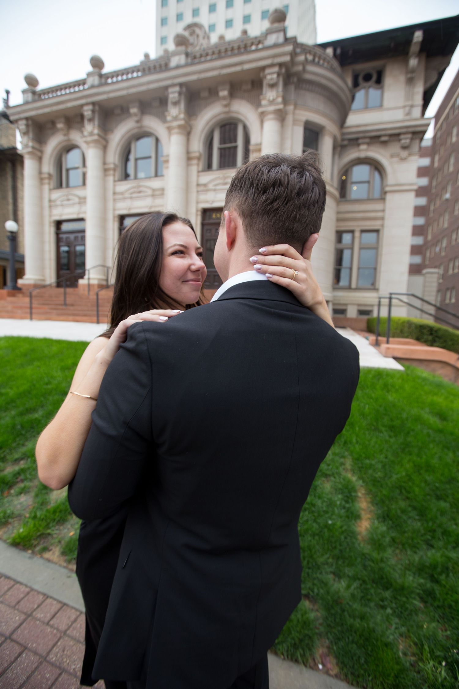 Couple sharing intimate moment outside ornate historic building.