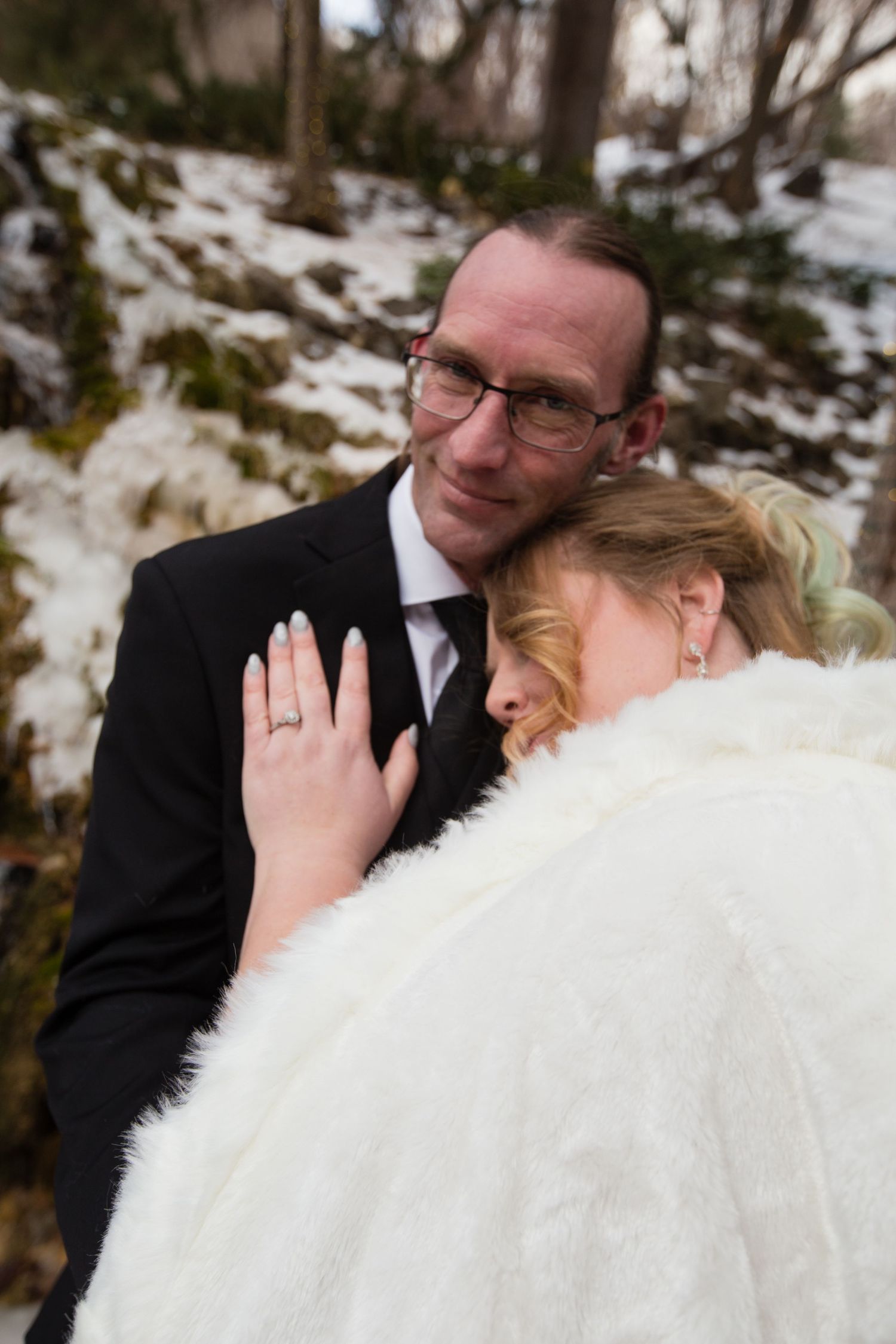 Intimate wedding portraits showing tender moments between newlyweds in a snowy winter setting.