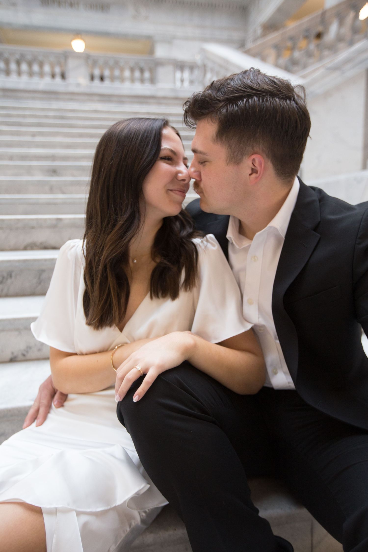 An intimate moment shared on grand marble steps in formal attire.
