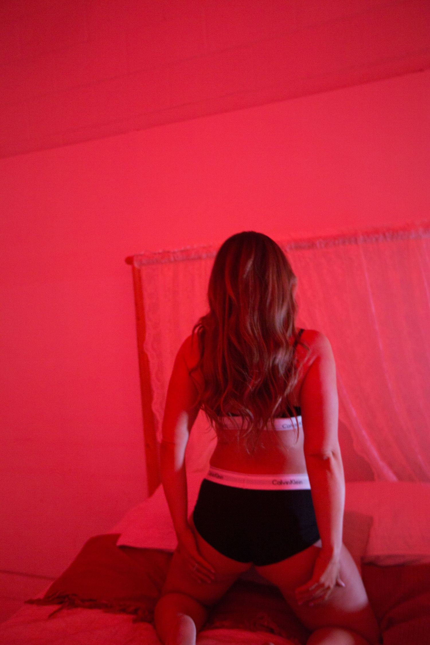 Artistic boudoir photo sequence with red lighting and dramatic shadows.