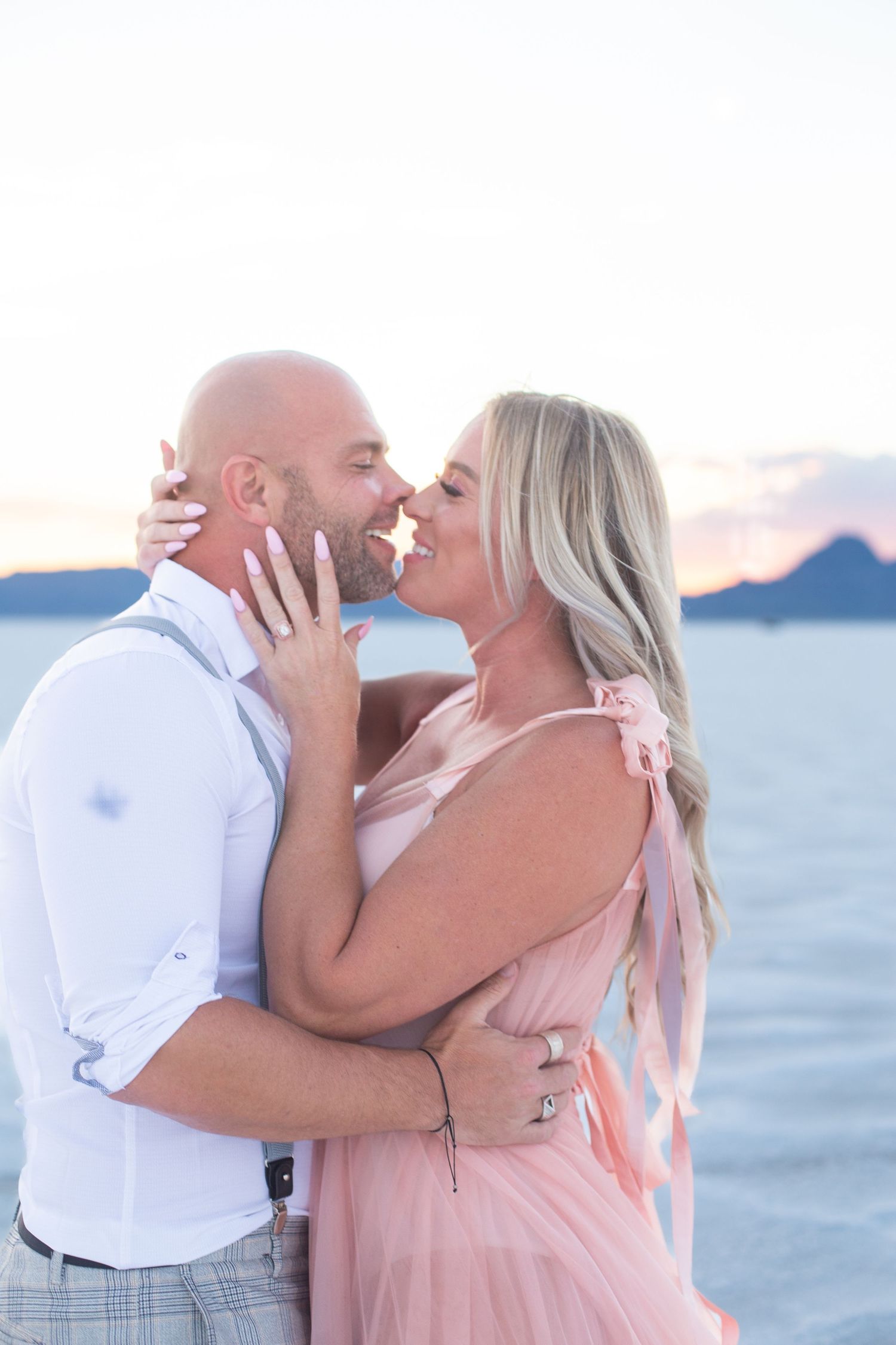 Loving couple embraces during sunset beach photography session.