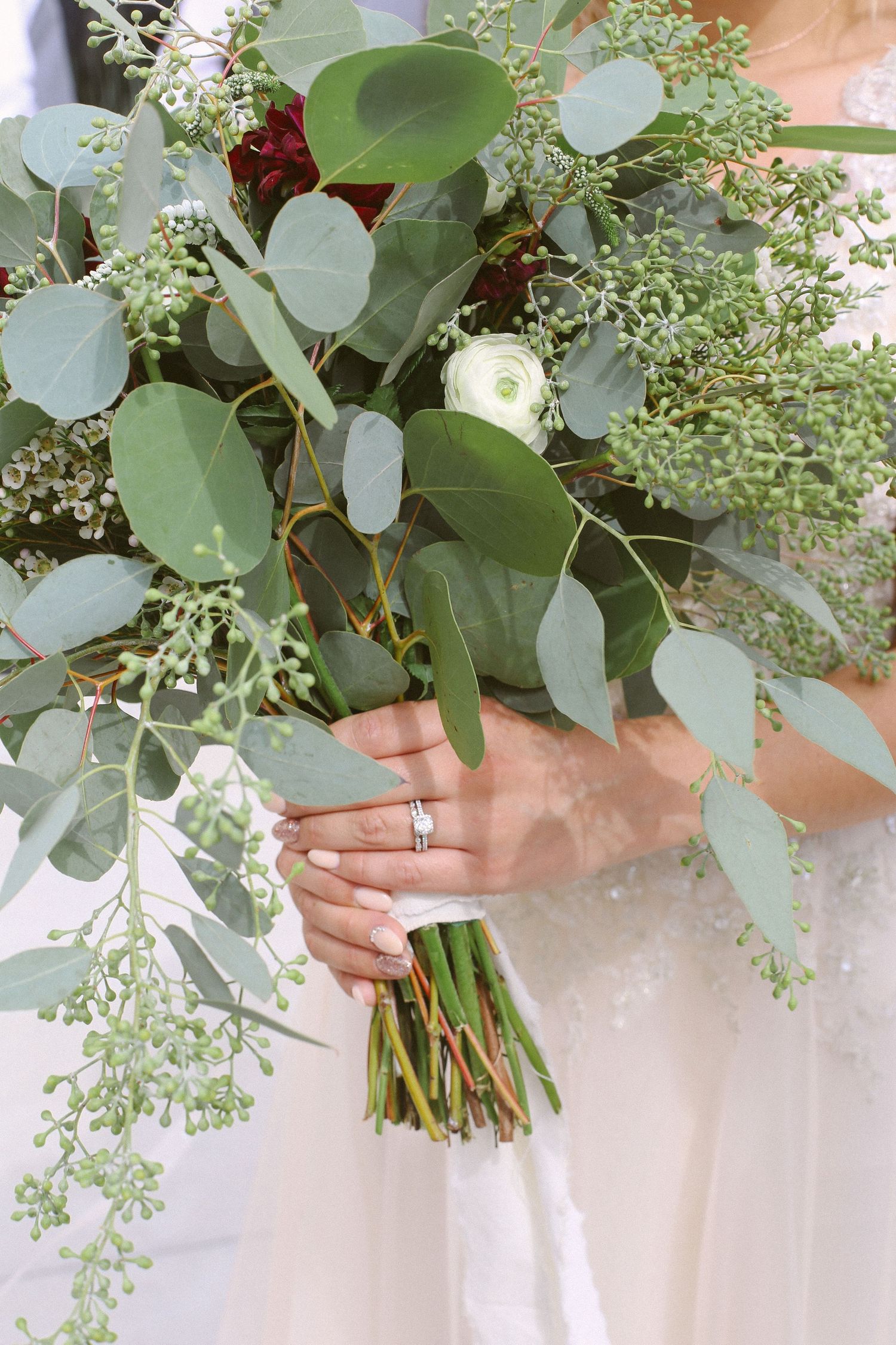 Close-up of a wedding bouquet featuring fresh eucalyptus leaves and delicate white flowers.