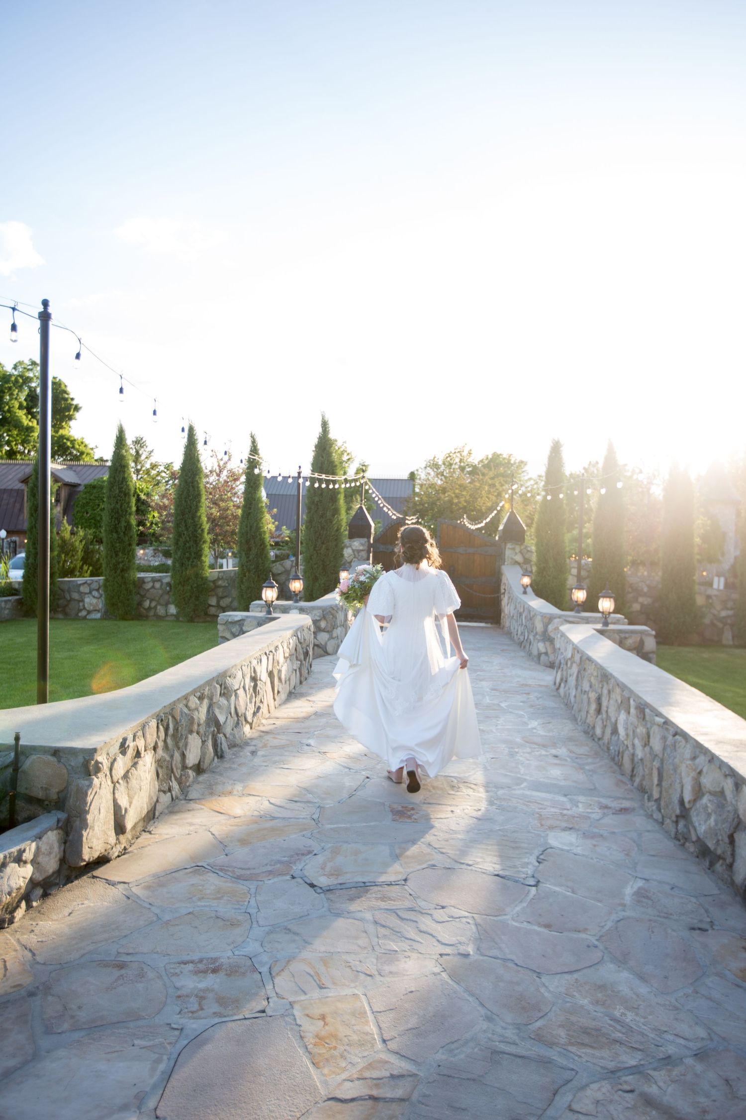 Stone pathway with ornate walls and castle-like architecture at sunset.