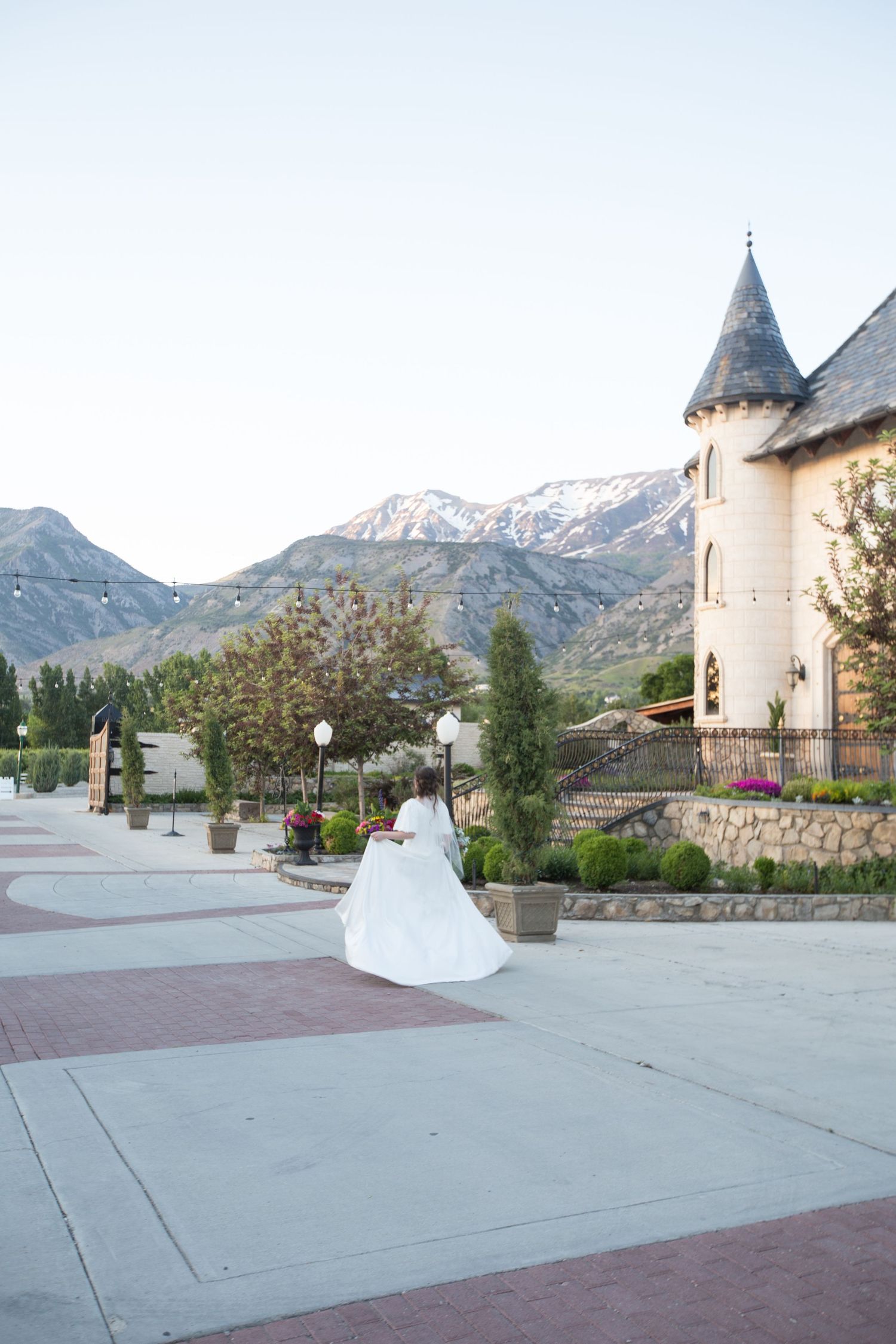 Castle-like venue with mountain peaks in the background during golden hour.