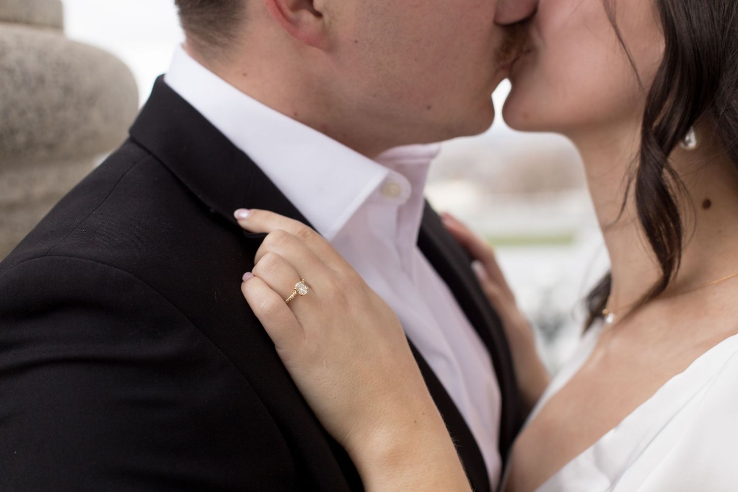 Close-up of an intimate moment showing a wedding ring and formal attire details.