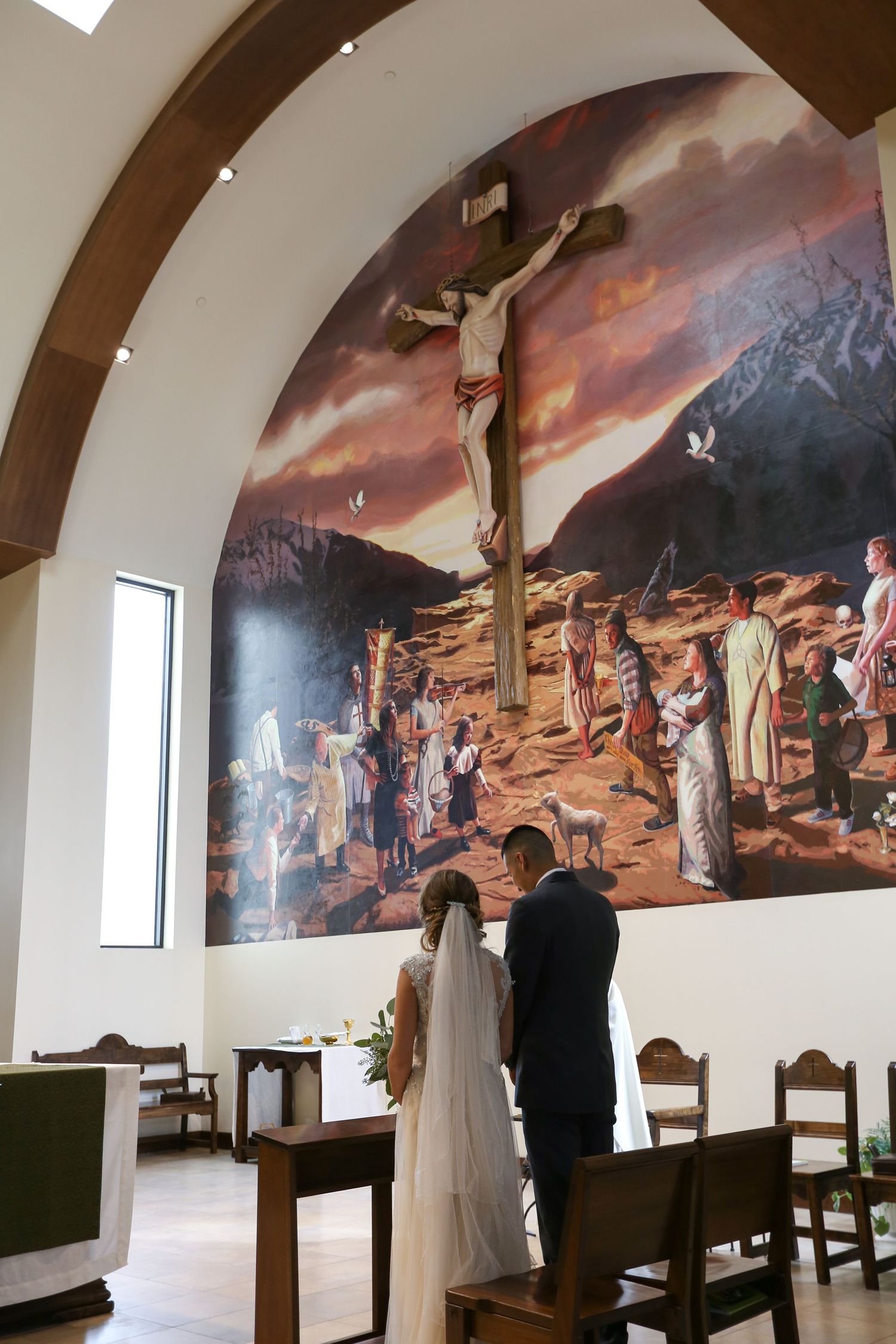 Church interior featuring dramatic religious murals and arched ceilings during a wedding ceremony.