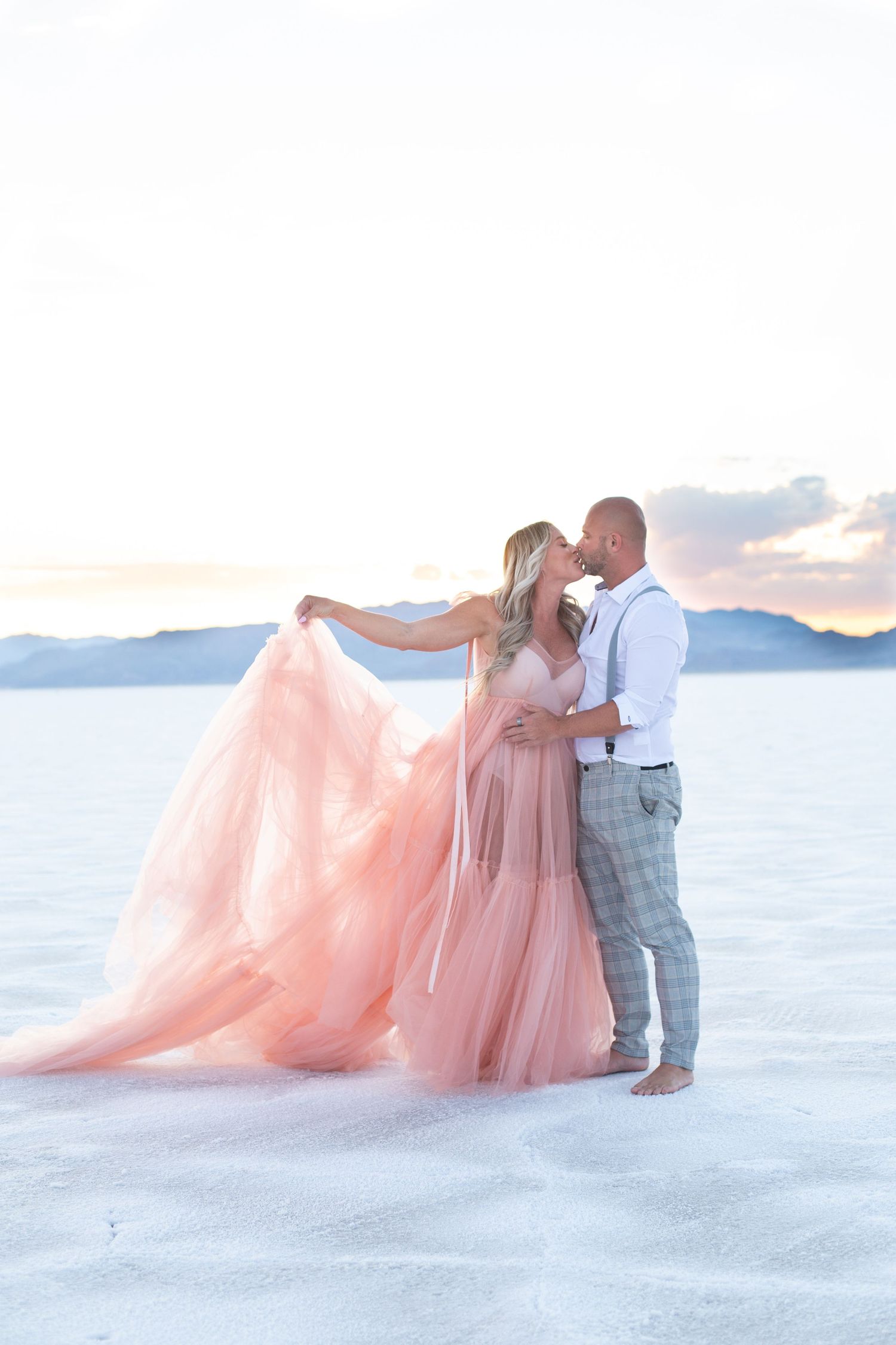 Wedding portraits on salt flats featuring a flowing pink princess gown.