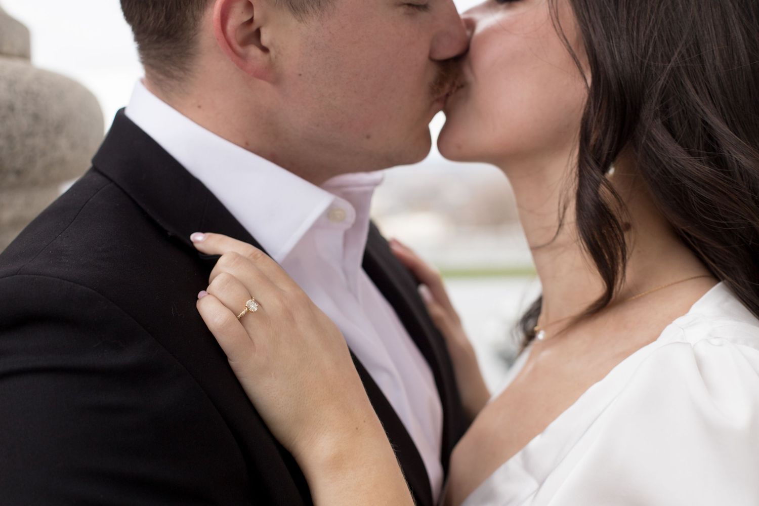 Close up shot of a tender kiss between newlyweds showing wedding ring detail.