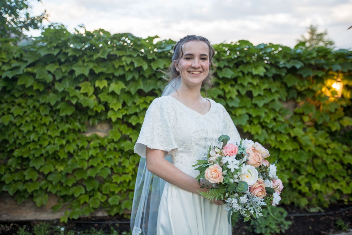 A romantic garden wedding photoshoot with soft lighting and ivy-covered walls.