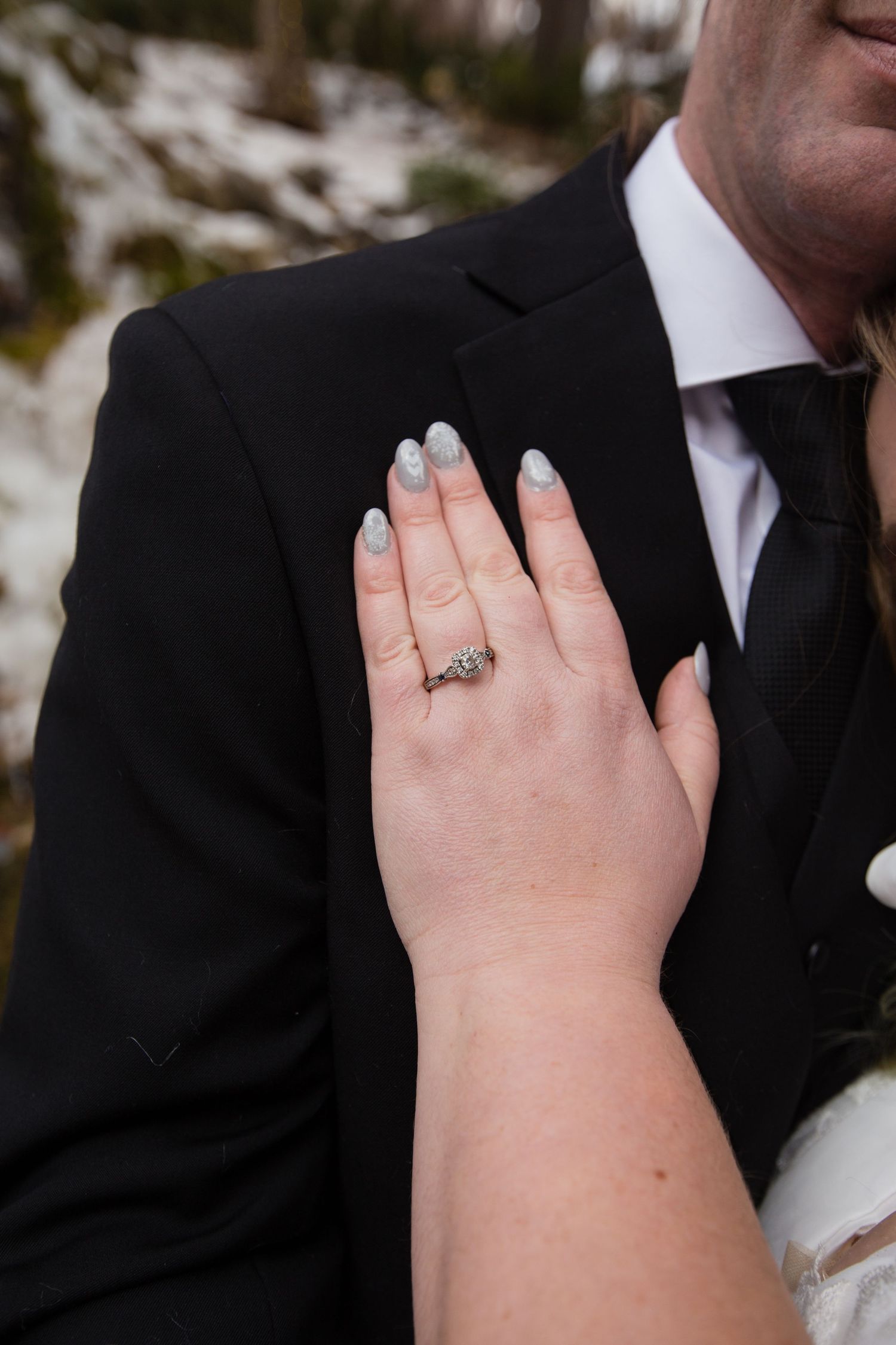 Close-up detail shot of wedding rings and hands during a winter wedding ceremony.