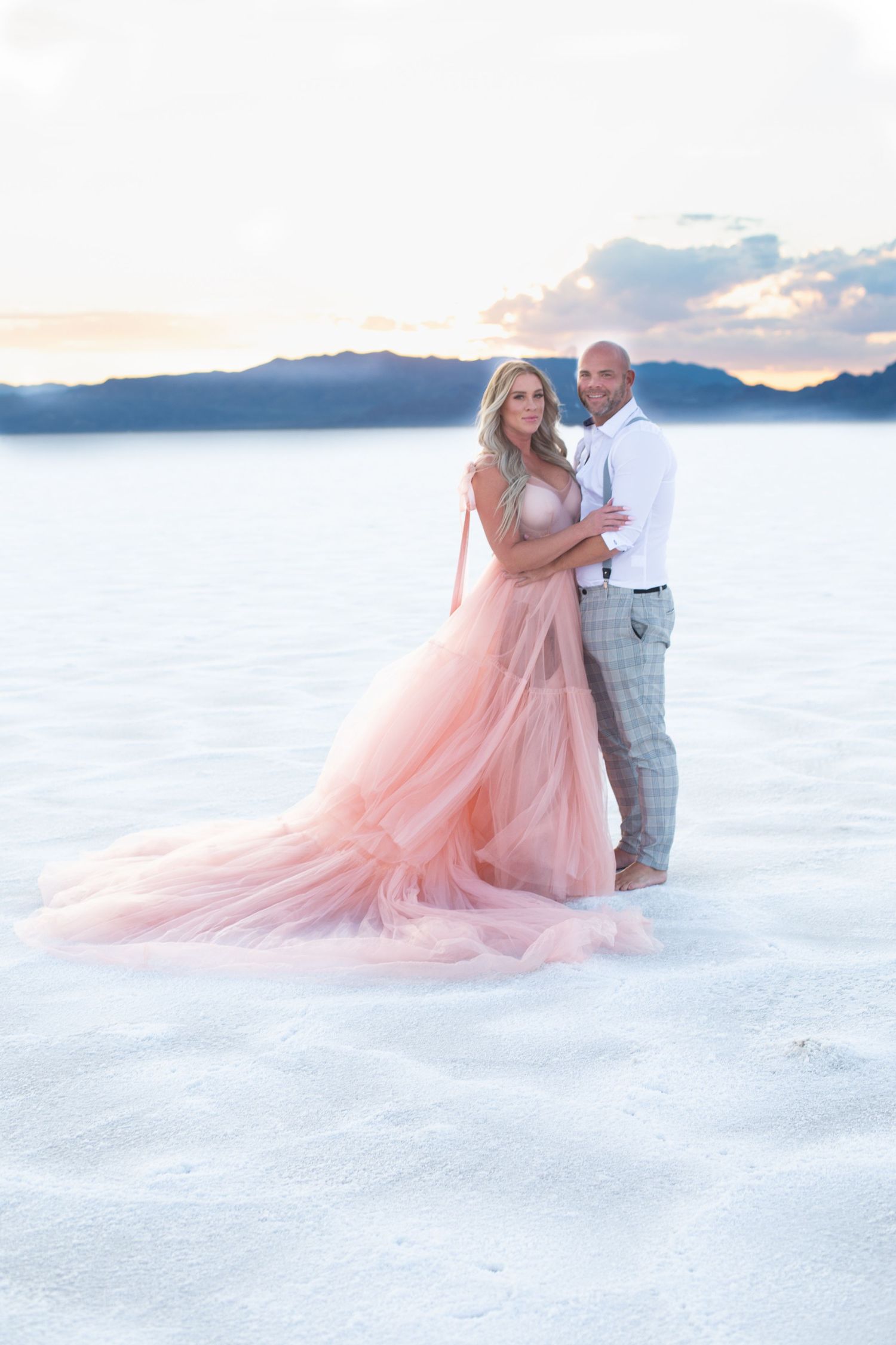 A dreamy wedding photoshoot on white salt flats with a flowing pink gown at sunset.