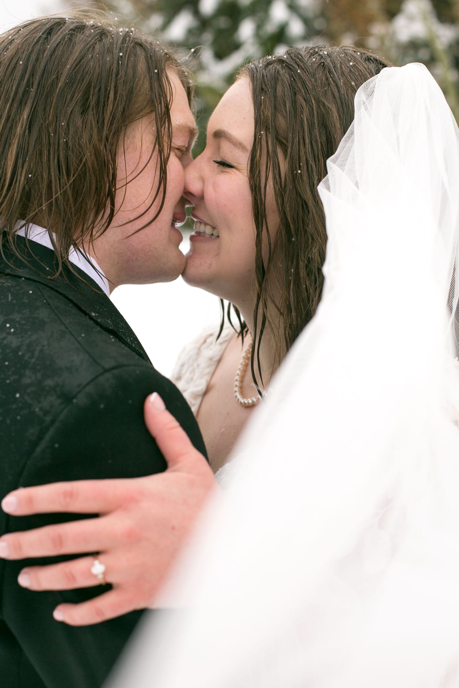 Close-up wedding photography capturing intimate moments in the rain.