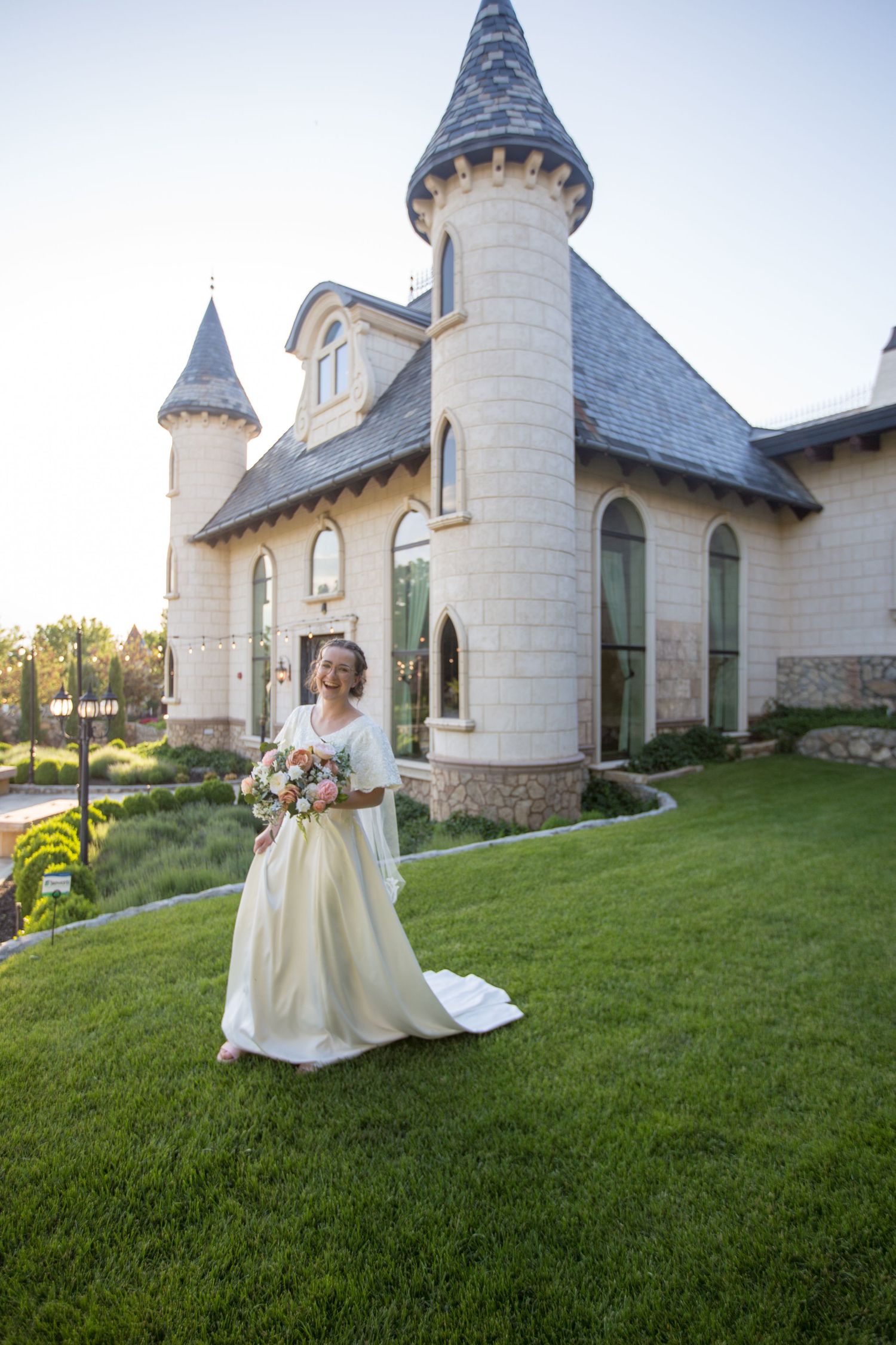 Stunning castle-inspired chapel with slate roof and turrets serves as backdrop for bridal photography.